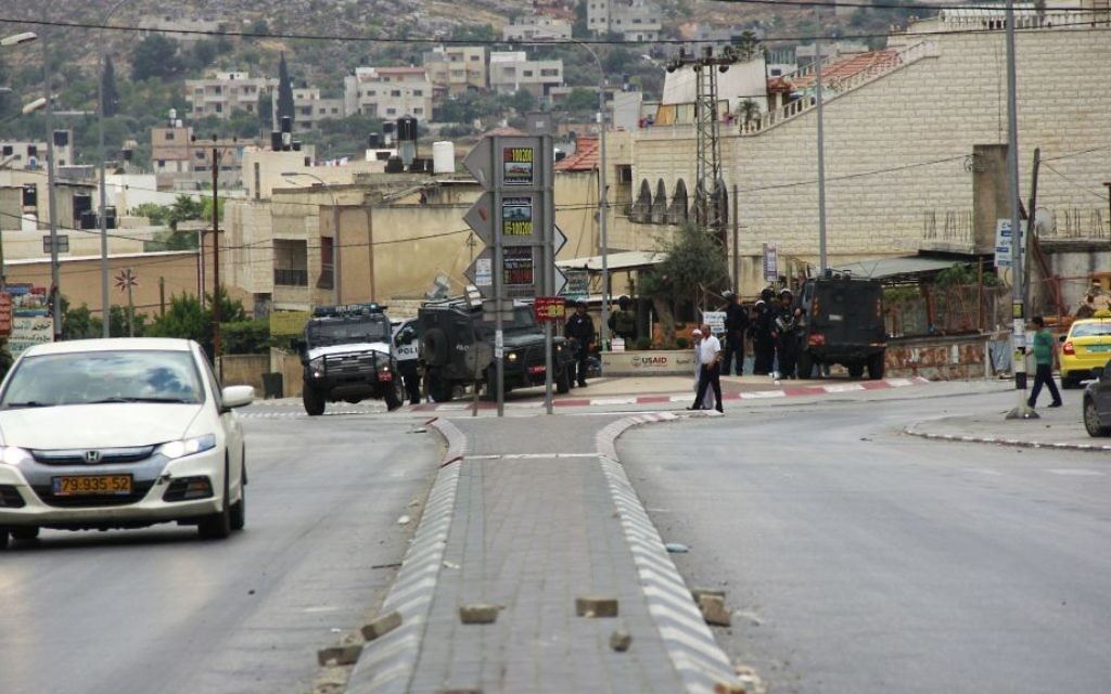 A car drives by the street where a group of Palestinians attacked an Israeli settler, who fired back, killing one person and wounding another, in Hawara, in the northern West Bank on May 19, 2017. (Judah Ari Gross/Times of Israel)