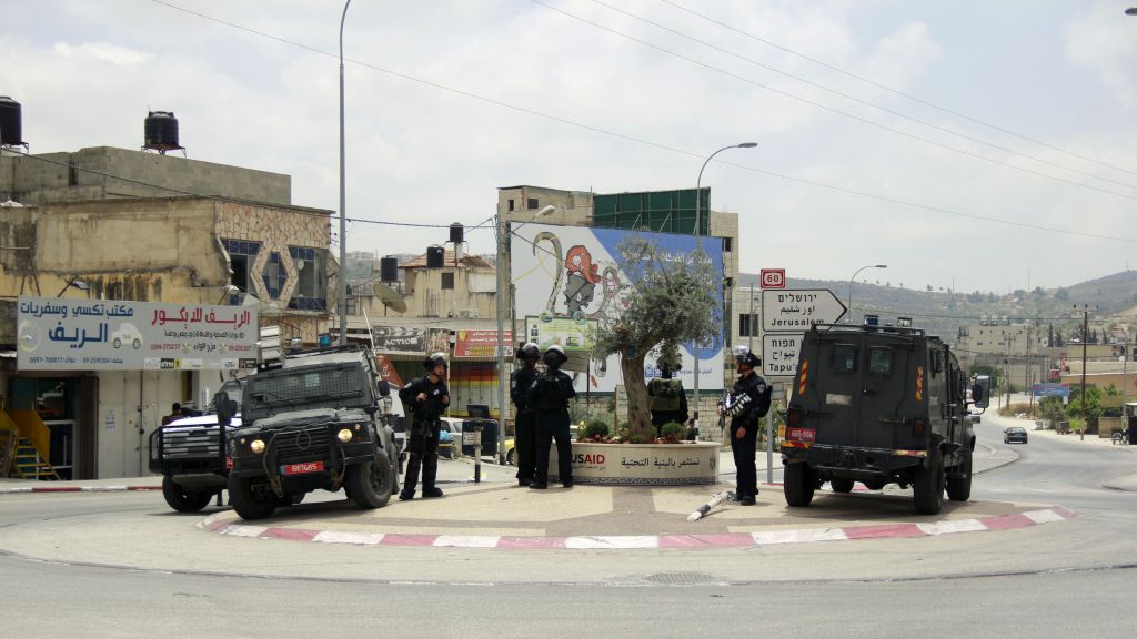 Israel Police officer guard a street where yesterday a group of Palestinians attacked an Israeli settler, who fired back, killing one person and wounding another, in Hawara, in the northern West Bank on May 19, 2017. (Judah Ari Gross/Times of Israel)