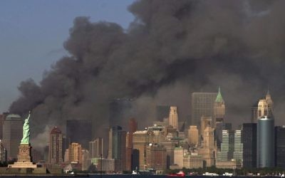In this Sept. 11, 2001 file photo, thick smoke billows into the sky from the area behind the Statue of Liberty, lower left, where the World Trade Center towers stood. (AP Photo/Daniel Hulshizer)