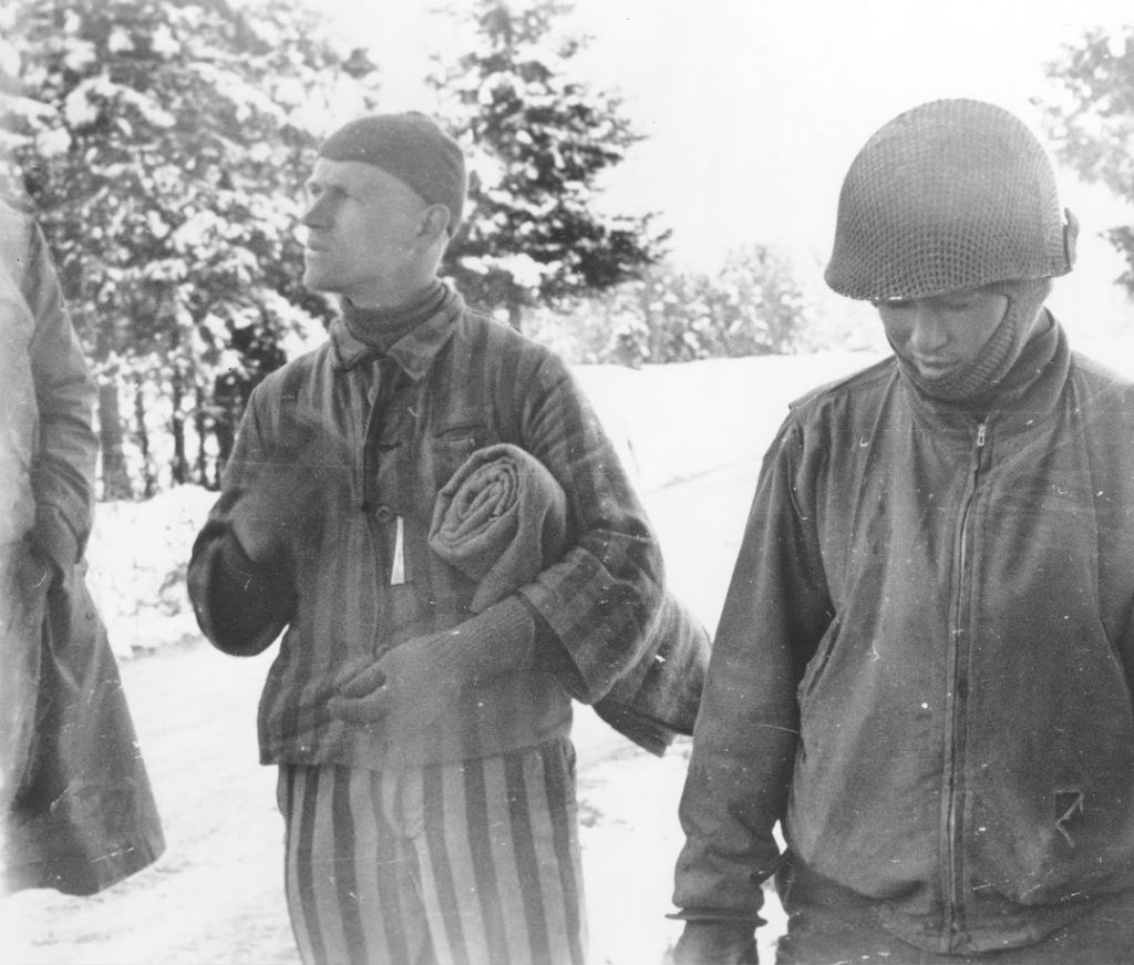 Tahae Sugita (right), a Japanese-American soldier with the 522nd Field Artillery battalion, stands next to a concentration camp survivor he has just liberated on a death march from Dachau. (Courtesy USHMM/Eric Saul)