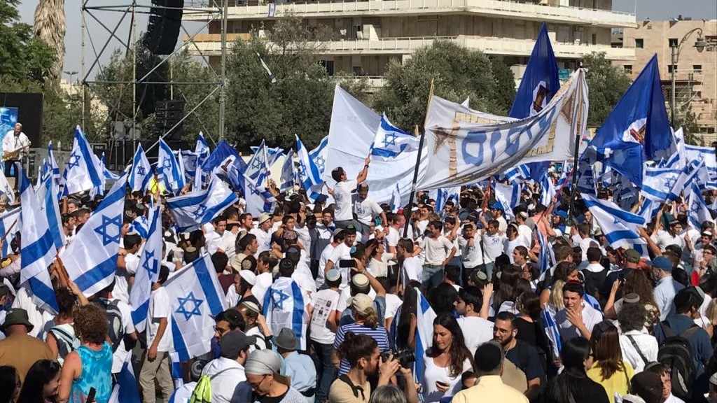 Hundreds of revelers wave Israeli flags as they they prepare to march their way through the city towards the Western Wall for Jerusalem Day. (Like Tress/Times of Israel) 