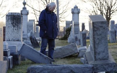 A man looks at fallen tombstones at the Jewish Mount Carmel Cemetery, February 26, 2017, in Philadelphia, PA. (DOMINICK REUTER/AFP/Getty Images, via JTA)