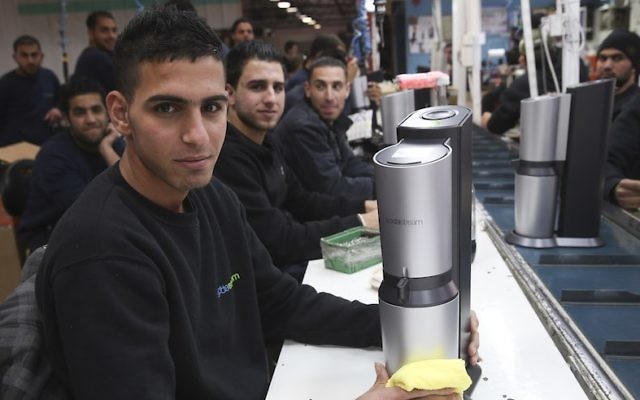Palestinians work at a SodaStream factory in the Mishor Adumim industrial park, next to the Ma'ale Adumim, February 2, 2014. (Nati Shohat/Flash90)