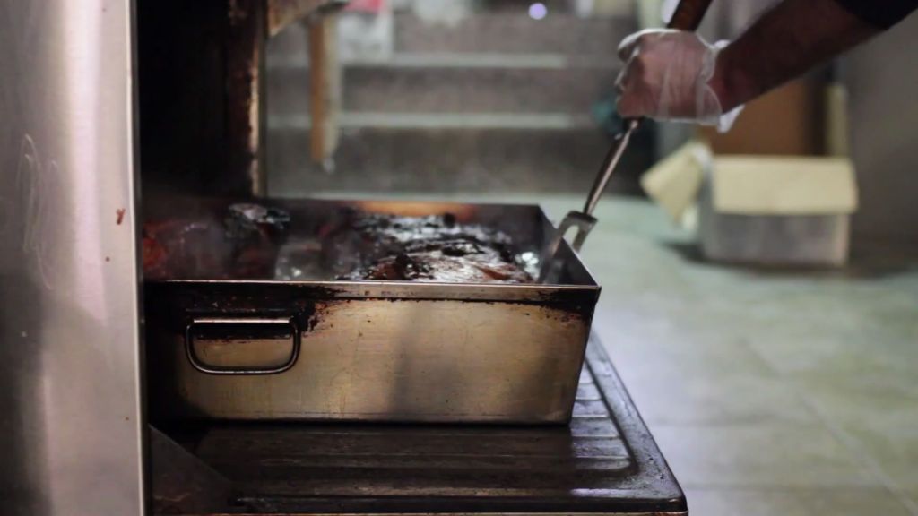 Pulling fresh braised brisket out of the oven at David's Brisket House in Brooklyn, New York. (YouTube Screenshot)