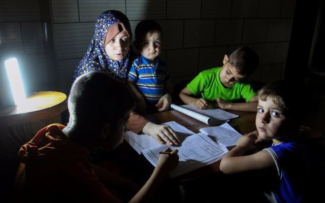 Palestinian boys study by lantern light, during a power outage in Rafah in the southern Gaza Strip on May 18, 2016. (Abed Rahim Khatib/ Flash90/File)