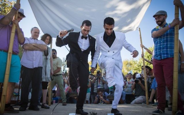 A gay couple has a symbolic wedding ceremony under a traditional wedding canopy during the annual Pride parade in Jerusalem, July 21, 2016. (Hadas Parush/Flash90)