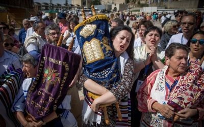 Members of the Reform and Conservative Jewish movements hold torah scrolls during mixed men and women's prayer at the public square in front of the Western Wall, in Jerusalem's Old City, on May 18, 2017. (Yonatan Sindel/Flash90)