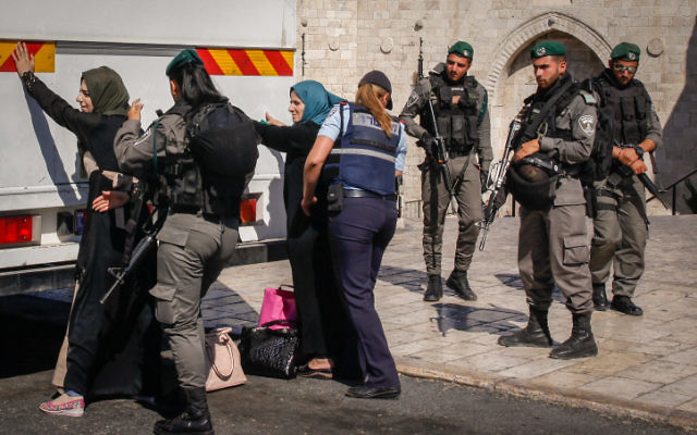 Israeli security forces check Palestinian women in front of the Damascus Gate in Jerusalem's Old City before allowing them to board a bus that will take them back to the West Bank on June 17, 2017. (Sliman Khader/Flash90)