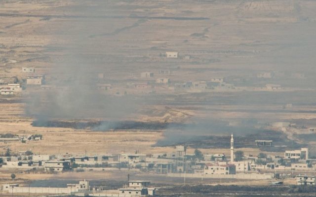A picture taken from the Israeli side of the border shows smoke rising at a Syrian village near the Israeli-Syrian border in the Golan Heights on June 24, 2017. (Basel Awidat/Flash90)