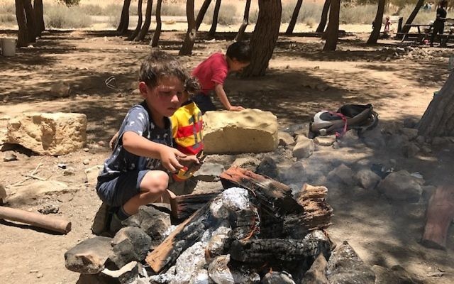 A boy tending a fire in Mitzpe Ramon, Israel, June 13, 2017. (Andrew Tobin) 
