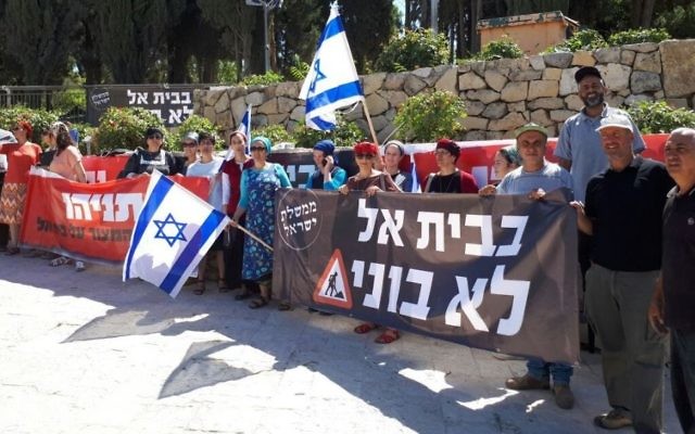Beit El residents hold signs at a protest outside the Prime Minister's Office in Jerusalem on June 19, 2017. (Courtesy)