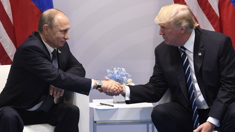 US President Donald Trump and Russia's President Vladimir Putin shake hands during a meeting on the sidelines of the G20 Summit in Hamburg, Germany, on July 7, 2017. (AFP Photo/Saul Loeb)