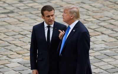 French President Emmanuel Macron (L) talks to US President Donald Trump during a welcome ceremony at Les Invalides in Paris, on July 13, 2017. (AFP Photo/Bertrand Guay)