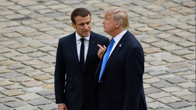 French President Emmanuel Macron (L) talks to US President Donald Trump during a welcome ceremony at Les Invalides in Paris, on July 13, 2017. (AFP Photo/Bertrand Guay)