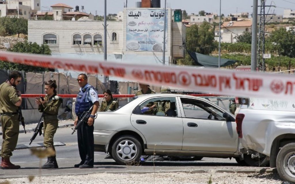 Israeli security forces gather at the scene of a car-ramming attack at the entrance to the West Bank village of Beit Anoun on July 18, 2017. (AFP Photo/Hazem Bader)