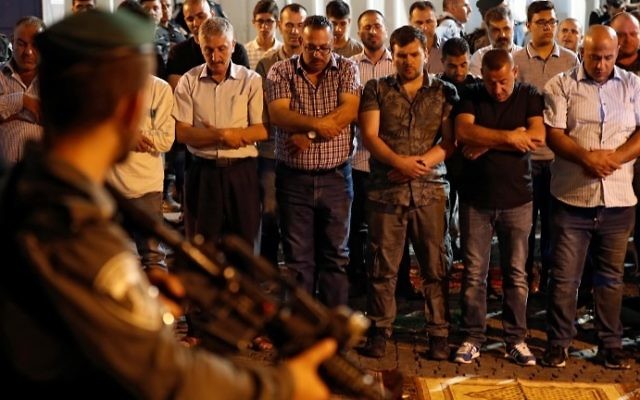 Israeli security forces stand guard in front of Muslim worshipers praying outside Lions Gate in Jerusalem's Old City, on July 19, 2017 AFP/ Ahmad GHARABLI)