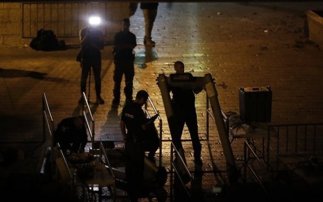 Israeli security forces take down metal detectors outside the Old City of Jerusalem's Lions Gate on July 24, 2017. (AFP Photo/Ahmad Gharabli)