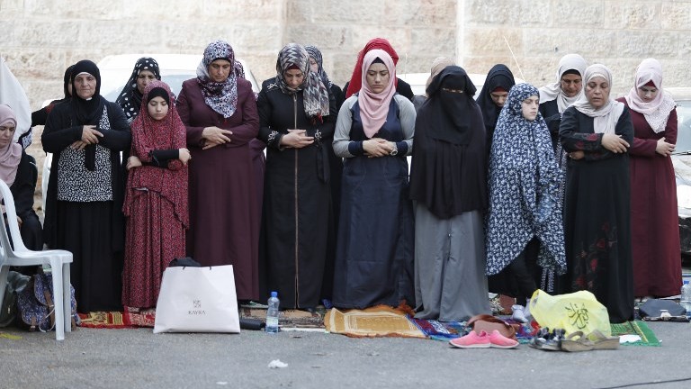 Muslim women pray outside Jerusalem's Old City on July 25, 2017. (AFP Photo/Ahmad Gharabli)