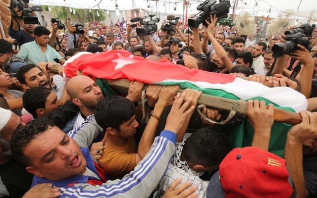 Mourners carry the body of 17-year-old Mohammed Jawawdeh, during his funeral on July 25, 2017, in Amman. (AFP PHOTO / KHALIL MAZRAAWI)