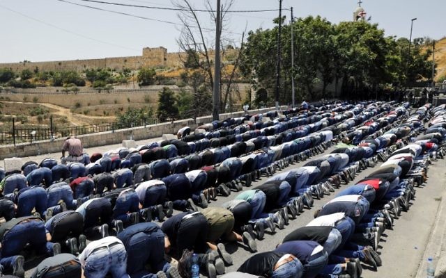 Muslim worshipers pray outside Jerusalem's Old City near the Lions' Gate on July 28, 2017. (AFP PHOTO / MENAHEM KAHANA)