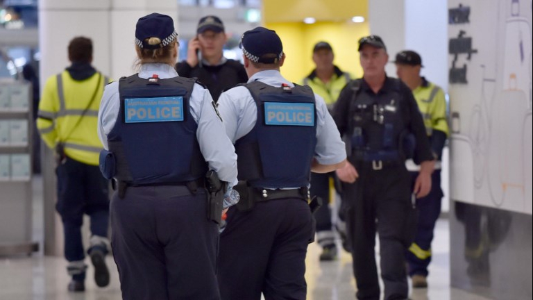 Police walk through the international terminal as they patrol Sydney Airport on July 31, 2017. (AFP PHOTO / PETER PARKS)