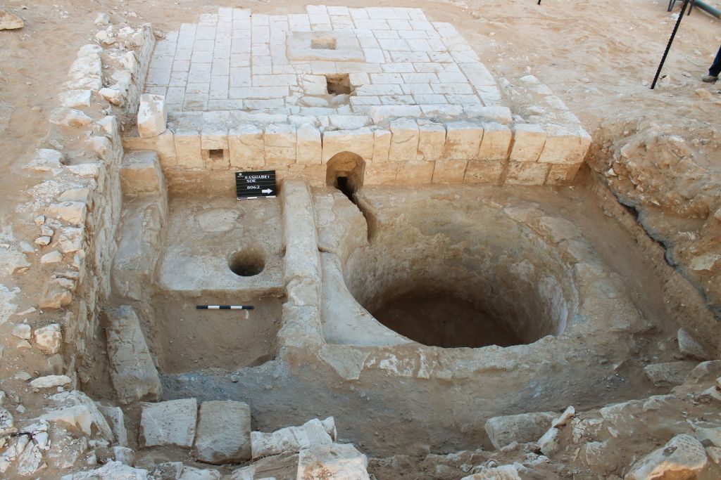 The wine press in Ramat Negev is intermeshed with a building, as seen in this summer 2017 photo. (Davida Dagan, Israel Antiquities Authority)