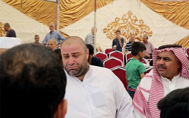 Zakaria al-Jawadah, center left, the father of Mohammed Mohammed al-Jawawdeh, a 17-year-old Jordanian, who attacked an Israeli security guard on Sunday evening and was shot dead, cries at a funeral tent in Amman, Jordan, Monday, July 24, 2017.  (AP Photo/Reem Saad)