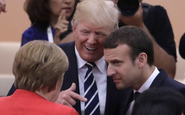 German Chancellor Angela Merkel, front, talks with US President Donald Trump, centre, and France's President Emmanuel Macron prior to the first working session on the first day of the G-20 summit in Hamburg, northern Germany, Friday, July 7, 2017. (AP Photo/Markus Schreiber)