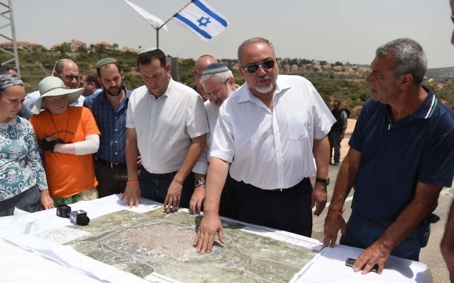 Defense Minister Avigdor Liberman presents his plan to allow Palestinians to expand the West Bank city of Qalqilya into area currently controlled by Israel, during a tour of the Maale Shomron settlement on July 12, 2017. (Eden Moldavski/Defense Ministry)