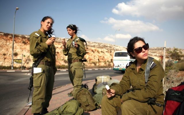 Israeli soldiers eating ice cream while waiting for a bus near Ramallah on October 1, 2009. (Matanya Tausig/Flash90)