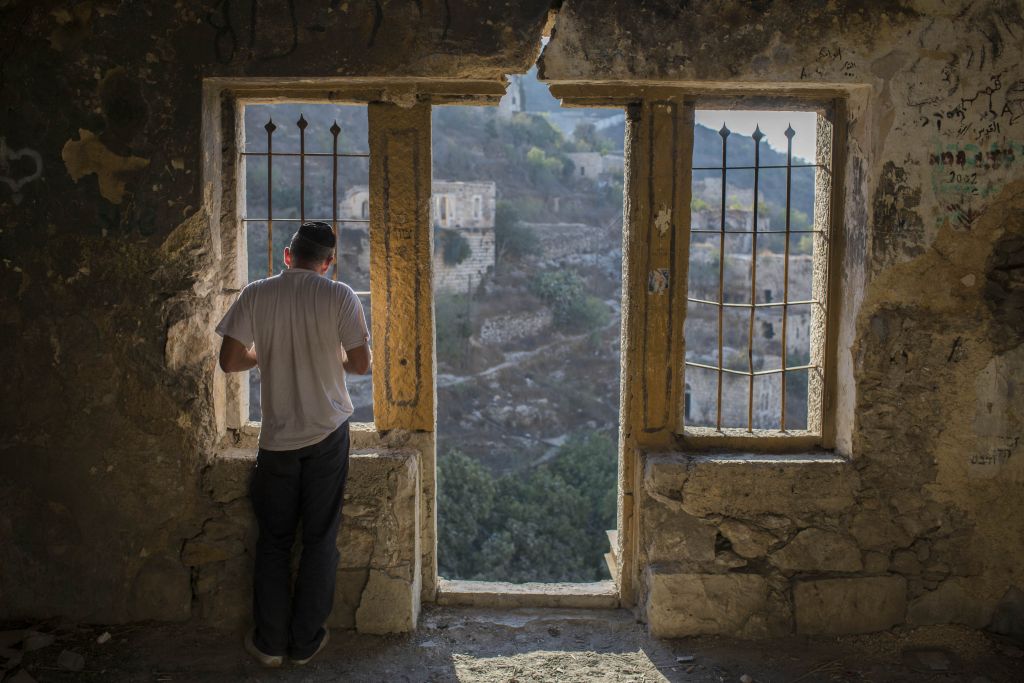 An Orthodox Jew recites the Tashlich prayer in a building in in Lifta, at the entrance to Jerusalem, near the Liftsa Spring. Tashlich ("casting off") is a practice performed on Rosh Hashanah, the Jewish New Year, when it is customary to throw pieces of bread into a natural body of flowing water to "cast away" the sins of the past year (Yonatan Sindel/Flash90)
