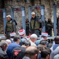 Waqf officials lead Muslim prayers outside the Temple Mount in Jerusalem's Old City on July 16, 2017 after refusing to go through metal detector gates set up by Israeli police. (Yonatan Sindel/Flash90)