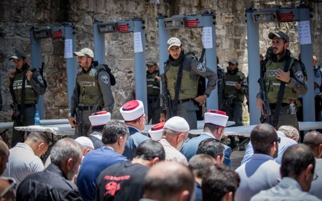 File: Waqf officials lead Muslim prayers outside the Temple Mount in Jerusalem's Old City on July 16, 2017, after refusing to go through metal detector gates set up by Israeli police. The gates were later removed. (Yonatan Sindel/Flash90)