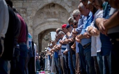 Muslim worshipers perform noon prayers the Lion's Gate, outside the Temple Mount, in Jerusalem's Old City on July 19, 2017. (Yonatan Sindel/Flash90) 