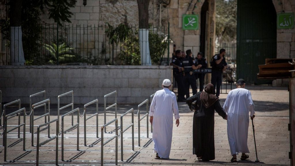 Police officers guard at an entrance to the Temple Mount, as a group of Muslims walk by metal railings installed at the site after a recent terror attack on July 25, 2017. (Hadas Parush/Flash90)