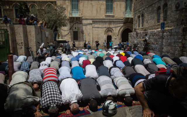 Muslim worshippers pray at an entrance to the Temple Mount at the Lion's Gate in Jerusalem's Old City, July 25, 2017. Muslim worshippers still refused to pray on the Temple Mount following the government's decision remove the metal detectors and instead place more security cameras on the compound. (Hadas Parush/Flash90)