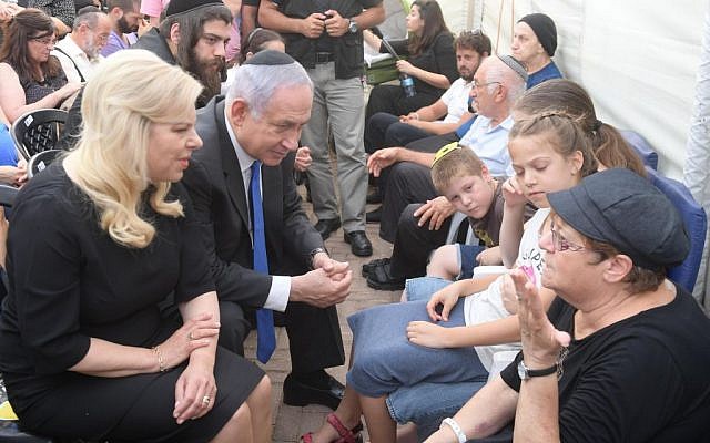 Prime Minister Benjamin Netanyahu and his wife Sara console relatives of the three members of the Salomon family who were killed in a terror attack in Halamish on July 22, 2017. (Amos Ben Gershom/GPO)