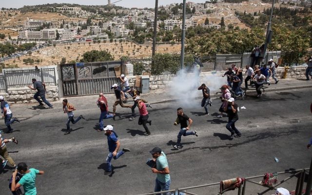 Palestinians run as Israeli police fire tear gas after Friday prayers in the East Jerusalem neighborhood of Wadi al-Joz, July 28, 2017 (Miriam Alster/Flash90)