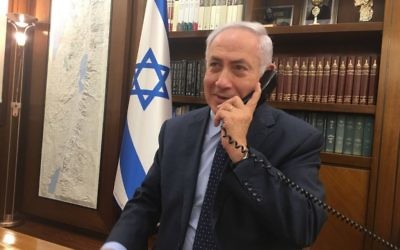 Prime Minister Benjamin Netanyahu speaks on the phone with Israel's ambassador to Jordan, Einat Schlein, and the security official who was stabbed and shot two Jordanians, on their return to Israel, July 24, 2017 (courtesy) 