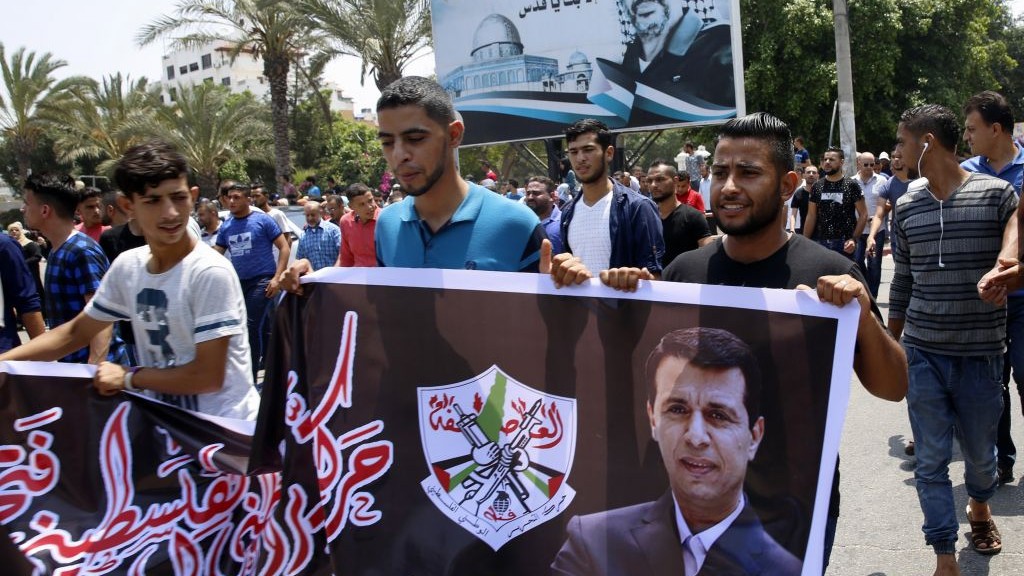Hundreds of supporters of exiled former Gaza strongman Mohammed Dahlan carry a banner with his picture during a protest in Gaza City on July 20, 2017. (AP Photo/Adel Hana)
