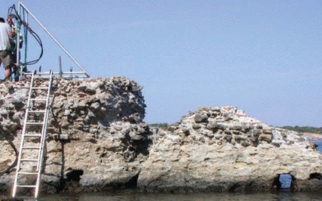 A scientist collects concrete samples from the Roman era Portus Cosanus pier in Orbetello, Italy (JP Oleson)