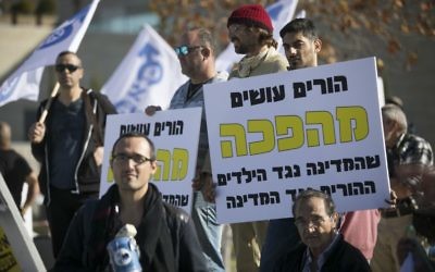 Activists holding signs in protest against the state's treatment of divorced fathers in front of the Supreme Court in Jerusalem, December 6, 2016. (Yonatan Sindel/Flash90)