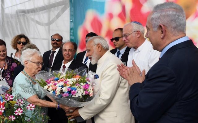 Indian Prime Minister Narendra Modi, center in white, is given a bouquet of flowers during a visit to the Dan Flower Farm accompanied by Prime Minister Benjamin Netanyahu, far right. (Haim Tzach/GPO)