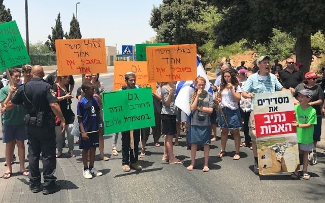 Netiv Ha'avot residents protest the High Court decision to demolish 17 structures of their outpost, demonstrating outside the Knesset on July 17, 2017. (Jacob Magid/Times of Israel)