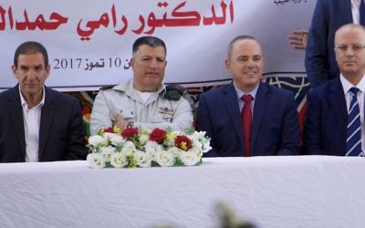 The coordinator of government activities in the West Bank Yoav (Poli) Mordechai (second from left) and Minister of National Infrastructure, Energy and Water Resources Yuval Steinitz sit with Palestinian Authority Prime Minister Rami Hamdallah (far right) and Yiftah Ron-Tal, head of the Israel Electric Corporation (far left), at a ceremony to mark the first-ever signing of a commercial agreement between the two authorities to increase electricity in the West Bank area of Jenin, July 10, 2017. (Dov Lieber for the Times of Israel) 