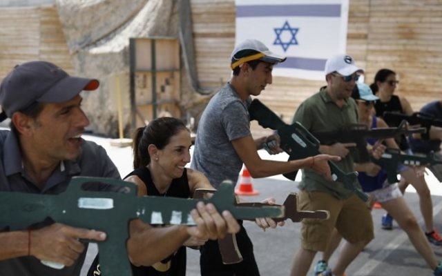 Foreign tourists train with a wooden gun as they participate in a two hour anti-terror course at the Caliber 3 shooting range, near the West Bank settlement of Efrat on July 18, 2017. (AFP PHOTO / MENAHEM KAHANA)