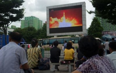 People watch as coverage of an ICBM missile test is displayed on a screen in a public square in Pyongyang on July 29, 2017. (AFP PHOTO / Kim Won-Jin)