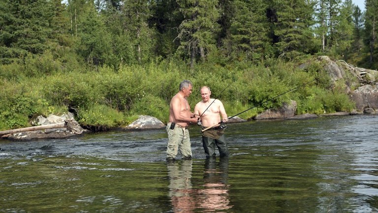 Russian President Vladimir Putin (R) and Defense Minister Sergei Shoigu fish in the remote Tuva region in southern Siberia. The picture was taken between August 1 and 3, 2017. (AFP Photo/Sputnik/Alexey Nikolsky)