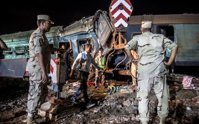 Emergency personnel and Egyptian military police search the wreckage of the train collision on August 11, 2017 near Khorshid station in Alexandria. (AFP PHOTO / KHALED DESOUKI)