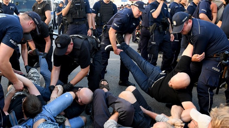 Police officers remove demonstrators who tried to block far-right extremists marching to celebrate the Polish Army Day, marking the victory of Polish troops against the Bolshevik army in 1920, on August 15, 2017 in Warsaw. (AFP Photo/Janek Skarzynski)